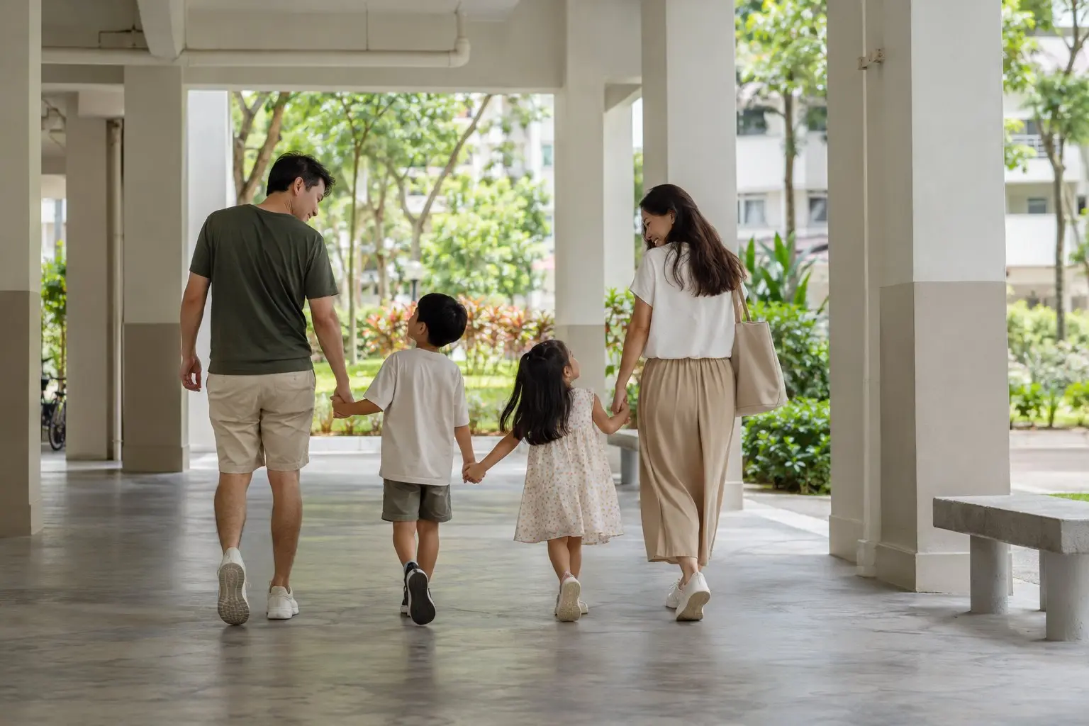 A family walking through the void deck of an HDB block